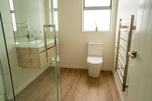 a bathroom with a toilet and a sink at Southern Peaks Hideaway in Queenstown Airport