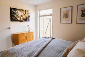 a bedroom with a bed and a window at Southern Peaks Hideaway in Queenstown Airport