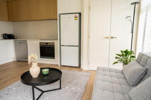 a living room with a couch and a table and a refrigerator at Southern Peaks Hideaway in Queenstown Airport