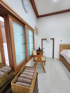 a bedroom with a bed and a table and a chair at Hanok Stay Ohneul in Gyeongju