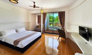 a bedroom with a bed and a television and a balcony at Rashu Hiyaa Hotel in Dhiffushi