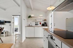 a kitchen with white cabinets and a counter top at Sct Knudsborg - 12H - Summerhouse on the beach in Brenderup