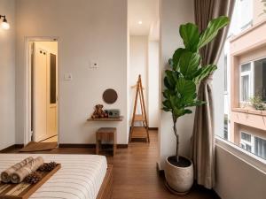 a bedroom with a bed and a potted plant at 1 House 2 in Da Lat