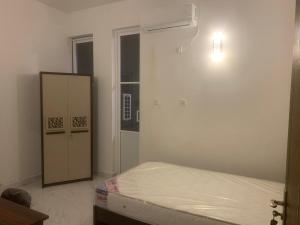 a bedroom with a bed and a light on the wall at Airport Transit Home in Ja-Ela