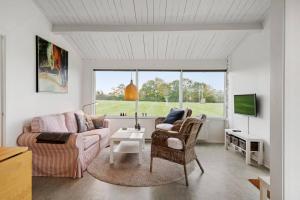 a living room with a couch and a table at Sct Knudsborg - 12J - Summerhouse on the beach in Brenderup