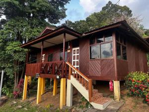 a small wooden house with a large window at Johans Chalet & Restaurant in Tioman Island