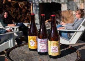 three bottles of beer sitting on top of a table at Bowen Island Ocean Retreat in Bowen Island