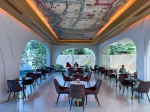 a dining room with tables and chairs and a coffered ceiling at The Rachata at Ayothaya in Ban Khlong Takhian