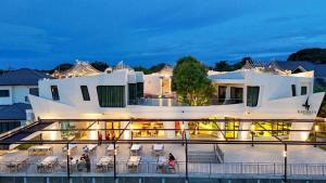 a large white building with tables and chairs at The Rachata at Ayothaya in Ban Khlong Takhian