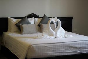 two swansrendered to look like birds sitting on a bed at Hotel De Kiang Muang in Chiang Mai