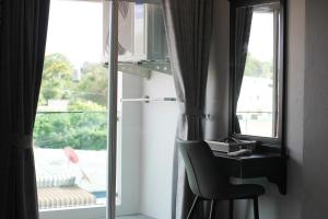 a room with a chair next to a window at Hotel De Kiang Muang in Chiang Mai