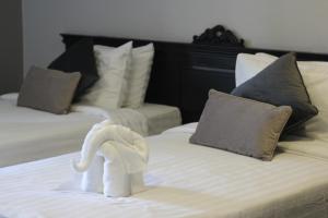 a towel animal is made to look like a swan on a bed at Hotel De Kiang Muang in Chiang Mai
