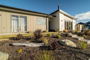 a house with a garden in front of it at Southern Peaks - Private Room in Queenstown Airport