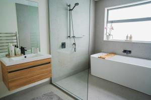 a bathroom with a shower and a tub and a sink at Southern Peaks - Private Room in Queenstown Airport +12 photos