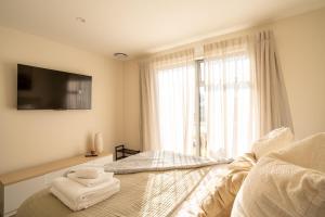 a bedroom with a bed with towels on it at Southern Peaks - Private Room in Queenstown Airport
