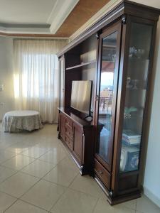 a living room with a entertainment center with a tv at Sunshine in Skala Marion