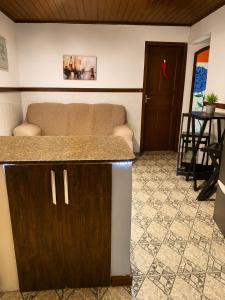 a living room with a couch and a counter top at Hostel amazonia in Búzios +37 photos