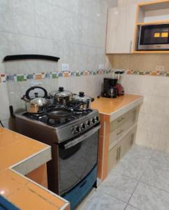 a kitchen with a stove and a counter top at Habitación completa in Huaraz