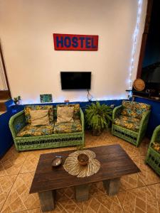 a living room with two couches and a tv at Hostel amazonia in Búzios