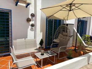 a patio with two chairs and an umbrella at Riviera garden 9 in Cabo Negro