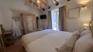 a bedroom with a large white bed and a window at Stazzu La Vigna Di Maria in Aglientu