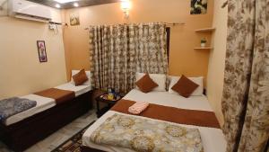 a small room with two beds and a window at KHS ROOMs near ghat and temples in Varanasi