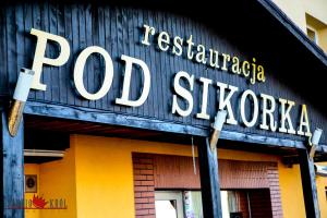 znak restauracji na boku budynku w obiekcie Restauracja i Noclegi Pod Sikorką w mieście Kobior