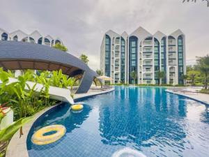 a swimming pool in front of some tall buildings at Title Naiyang Walk To Beach C111 in Nai Yang Beach +20 photos