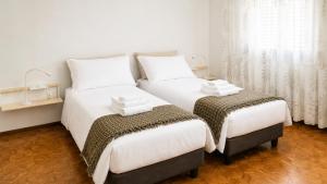two beds sitting next to each other in a room at Appartamento Casa Viola in Monclassico