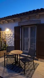 a table and two chairs on a patio at Stazzu La Vigna Di Maria in Aglientu