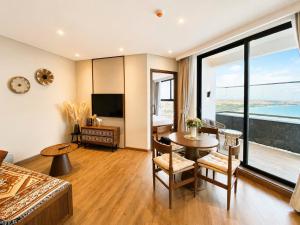 a living room with a bed and a table and a television at Mandala Cham Bay Mũi Né in Mui Ne