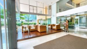 a lobby with couches and chairs in a building at Olive Hotel & Residence Bangkok Sukhumvit 101 near True Digital Park in Bangkok +56 photos