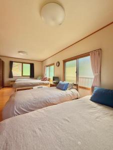 a room with three beds in a room at Takumisou 2 in Kiso