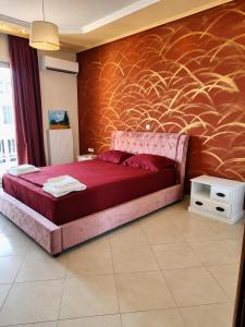 a bedroom with a large red bed with a wall at Sunshine in Skala Marion
