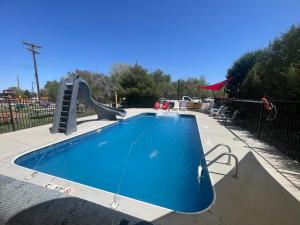 a small swimming pool with a slide in a playground at La Junta Camping & Cabins in La Junta
