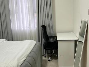 a bedroom with a bed and a desk and a computer at Serenity Residences 1BR Ruaka Near Two Rivers & UN Gigiri in Nairobi