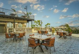 a patio with tables and chairs and a building at Tripli Regalia Mayur Palace in Udaipur