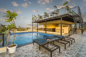 a house with a swimming pool and a balcony at Tripli Regalia Mayur Palace in Udaipur