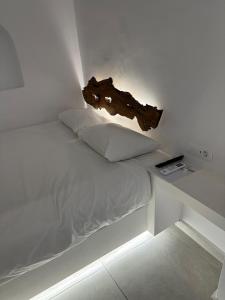 a white bed with a log on top of it at Eternal Town in Mikonos
