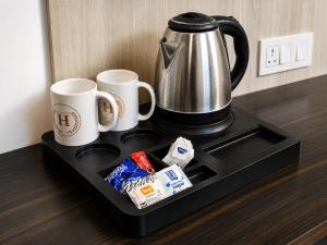 a coffee pot and two mugs on a tray at Kavin Highland - The Mall Dalhousie in Dalhousie