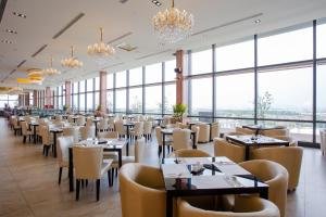 斗六市三好国际酒店的有桌椅和大窗户的餐厅