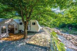 a campsite with a tent and a tree at Jirisan Forest Caravan Park in Gurye +13 photos