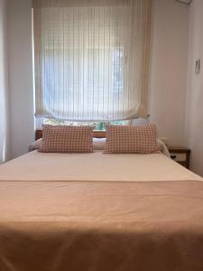 a bed with two pillows in front of a window at Balcón de La Iruela II in La Iruela
