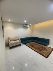 a living room with a blue couch and a chair at Green Stays in Comilla