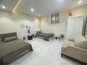 a living room with two beds and a couch at Green Stays in Comilla