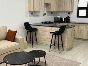 a kitchen with a couch and two chairs and a table at Serenity Residences 1BR Ruaka Near Two Rivers & UN Gigiri in Nairobi
