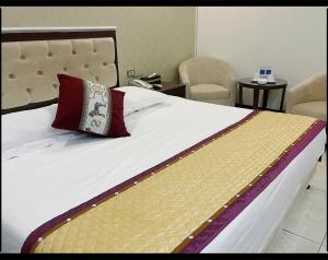 a bed with a pillow on it with two chairs at Khách sạn Rosy in Hòa Ðình