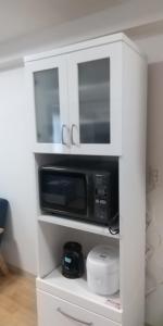 a microwave in a white cabinet in a kitchen at メープル桑園駅202 in Sapporo