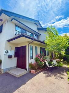a house with a red door and a balcony at Takumisou 2 in Kiso