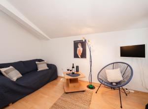a living room with a blue couch and a chair at Apartments Roda in Supetar